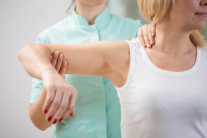 doctor examining patient's shoulder pain